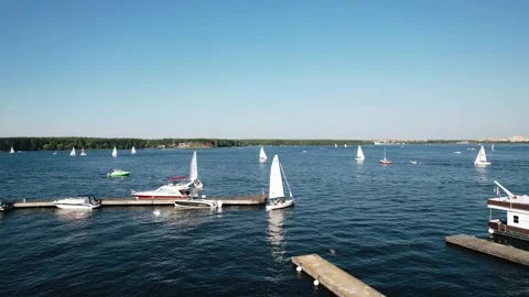A small sailboat goes out into the open water on the lake. Aerial photography Stock Footage 318964899