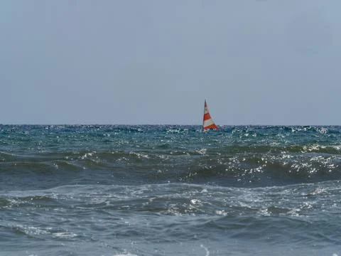 Small sailing boat in  the waves of the rough sea Stock Photos