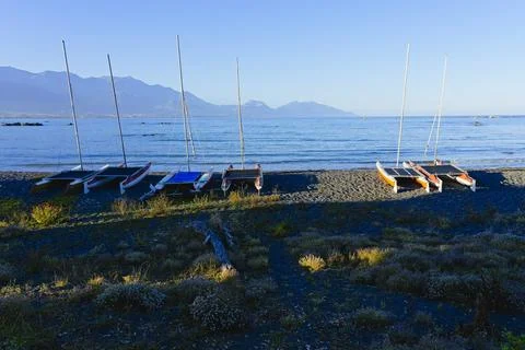 Small sailing catamarans beached high on Kaikoura's stony beach. Stock Photos