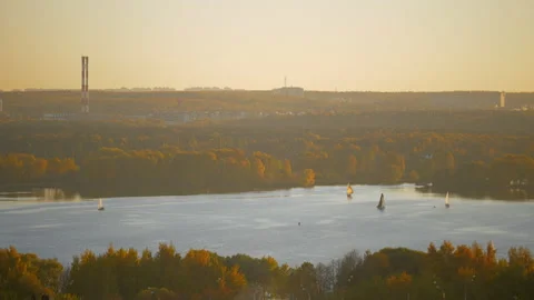 Small sailing yachts in the bay at sunset. Surrounded by an orange forest Stock Footage 163374191