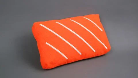 Small Salmon Slice Shaped Foam Cushion on Gray Background Stock Photos