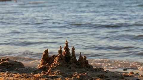 A Small Sandcastle on Beach With Waves on the Background Stock Footage 52311209