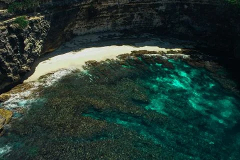 Small Sandy Beach infront of Stone arch over the sea on Broken beach, Nusa Stock Photos