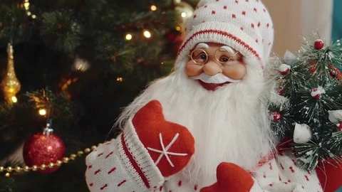 Small Santa Claus rag doll is standing near tiny Christmas tree, camera moves Stock Footage 84604338