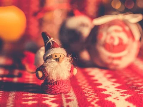Small Santa toy on red pattern table. Decoration for holidays 2020 Stock Photos