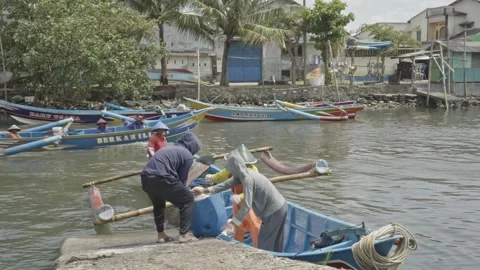 Small Scale Fishermen Unloading Catch Near Harbor Estuary Vidéo 333981844