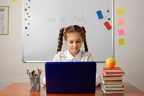 Small school girl working at the computer Stock Photos