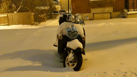 Small scooter covered in snow Stockbeeldmateriaal 125550906