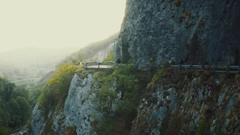 Small scooter driving on empty narrow serpentine mountain road at summer sunny Stock Footage 140006288