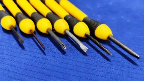 Small Screw Driver mini precision set on blue textured background. Stock Photos