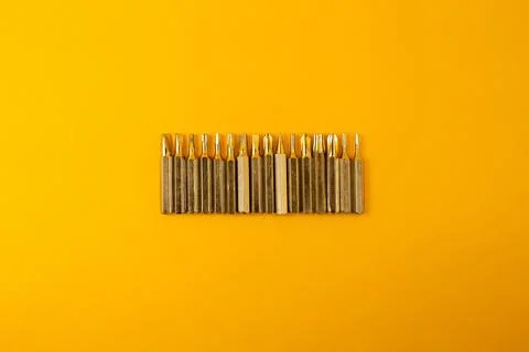 Small screwdriver bits on a yellow background Stock Photos
