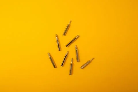 Small screwdriver bits on a yellow background Stock Photos