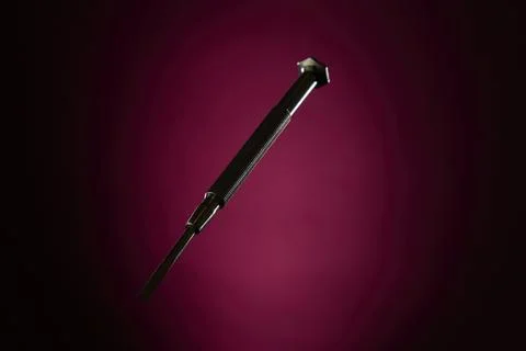 Small screwdriver on magenta gradient background minimal industrial concept Stock Photos