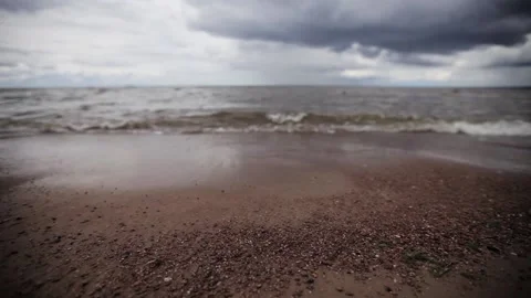 Small sea waves on beach with tiny stones. Grey cloud sky. Summer. Slider pan. 스톡 동영상 151321886