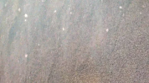 Small sea waves of clear transparent water roll on the sandy shore close-up. Stock Footage 212891265