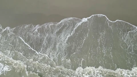 Small sea waves gently crashing onto the beach, creating a soothing and rhythmic Stock Footage 287779686