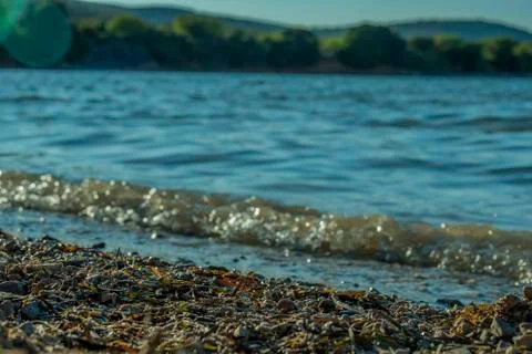 Small sea waves hitting sandy shore  Stock Photos
