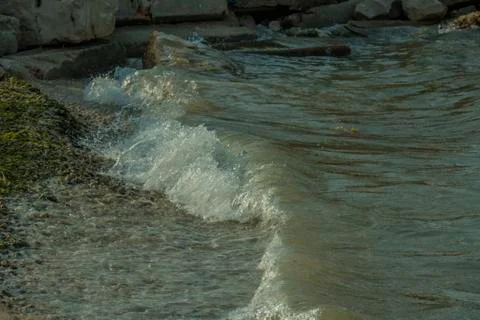 Small sea waves hitting sandy shore  Stock Photos