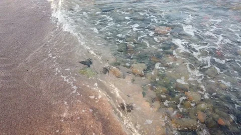 Small sea waves rush onto the shore from small pebbles. Peace from the moveme Stock Footage 220663959