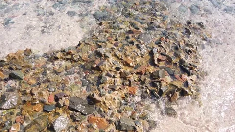 Small sea waves rush onto the shore from small pebbles. Stock Footage 223182580