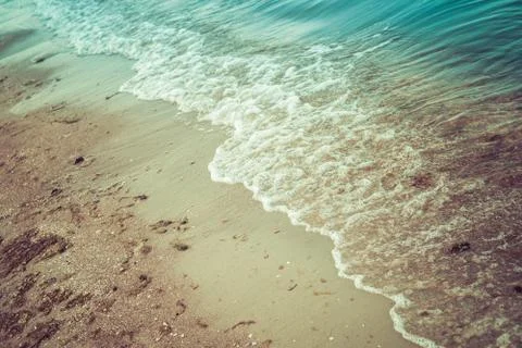 Small sea waves on a sandy beach Stock Photos