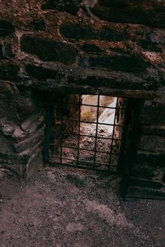 Small secret window with bars in an ancient castle Stock Photos