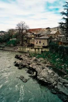Small settlement next to a mountain river rapids at sunset Stock-Fotos