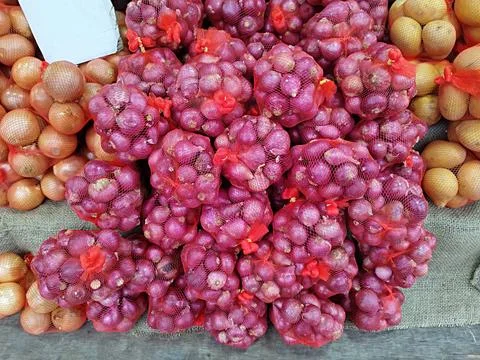 Small shallots in net packaging to make it easier for customers Stock Photos