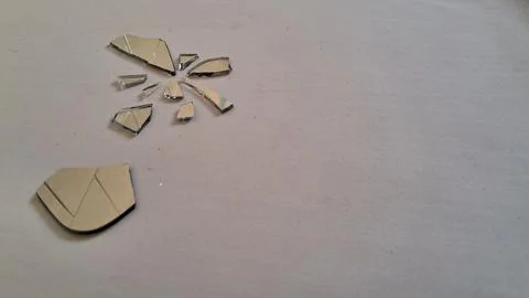 Small sharp jagged shards of a broken silver glass mirror Stock Photos