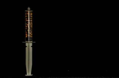 A small, sharp object is shown in a dark background Stock Photos