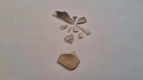 Small sharp shards of broken mirror scattered on white background Stock Photos