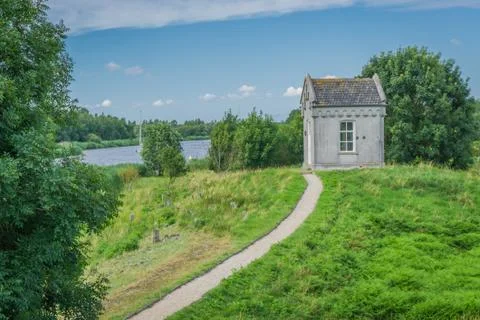 Small shed looking like a crypt with path at the lake Stock Photos
