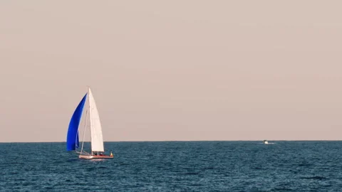 Small ship with a blue sails moving on the sea in Golfe-Juan, France Stock Footage 295609562