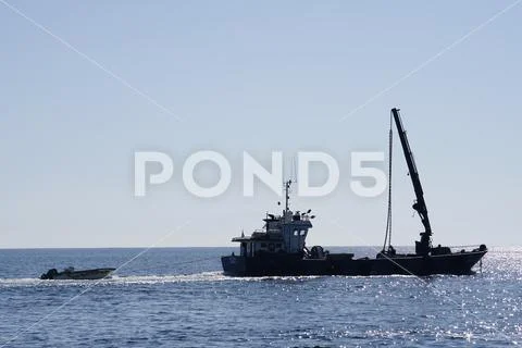 Small ship with a crane Stock Photos