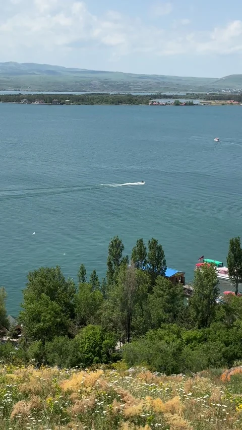 A small ship cuts through the water surface of a mountain lake Stock Footage 312827256