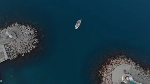 A small ship or boat sails into the bay at dawn. Video stock 220853920
