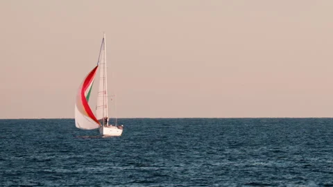 Small ship with a red sails moving on the sea in Golfe-Juan, France Stock Footage 295610459