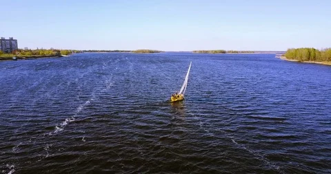 Small ship sails. Sunny landscape of the river in windy weather Stock Footage 74510026