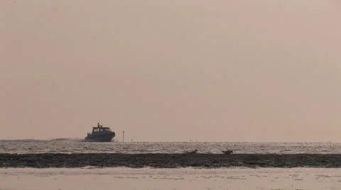 Small ship speeding across water at sunset Stock Footage 25645153