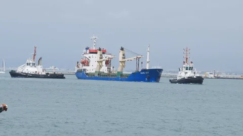 Small ship with tugs one enter the port while port police cross  4k Stock Footage 89250105
