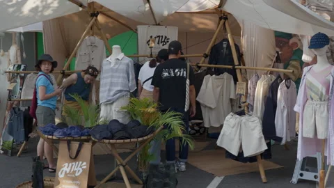Small shops selling clothes and fashion accessories at the Greenheart market Stock Footage 243799834