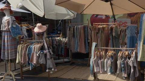 Small shops selling clothes and fashion accessories at the Greenheart market Stock Footage 243799980
