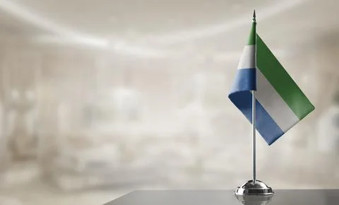 A small Sierra Leone flag on an abstract blurry background Stock Illustration