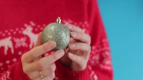 A small silver Christmas tree ball in female hands Stock Footage 258012991