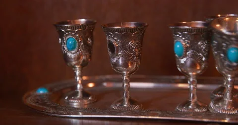 Small silver goblets with carvings and decorated with precious stones stand on Stock Footage 197343496
