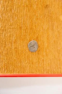 A small silver object is sitting on a yellow surface. in Chennai Stock Photos