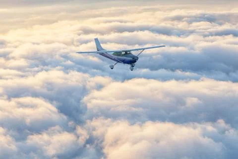 Small single engine airplane flying in the gorgeous sunset sky 스톡 사진