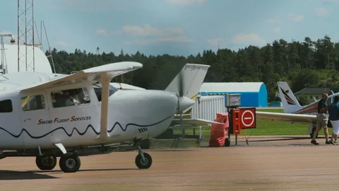 Small Single Engine Plane Taxiing Past Other Aircraft on a Sunny Day at a Stock Footage 99376166