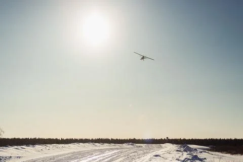 Small single-propeller plane flying over the blue sky. Stock Photos