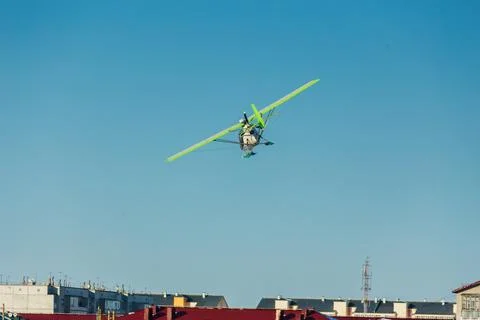 Small single-propeller plane flying over the blue sky. Stock Photos